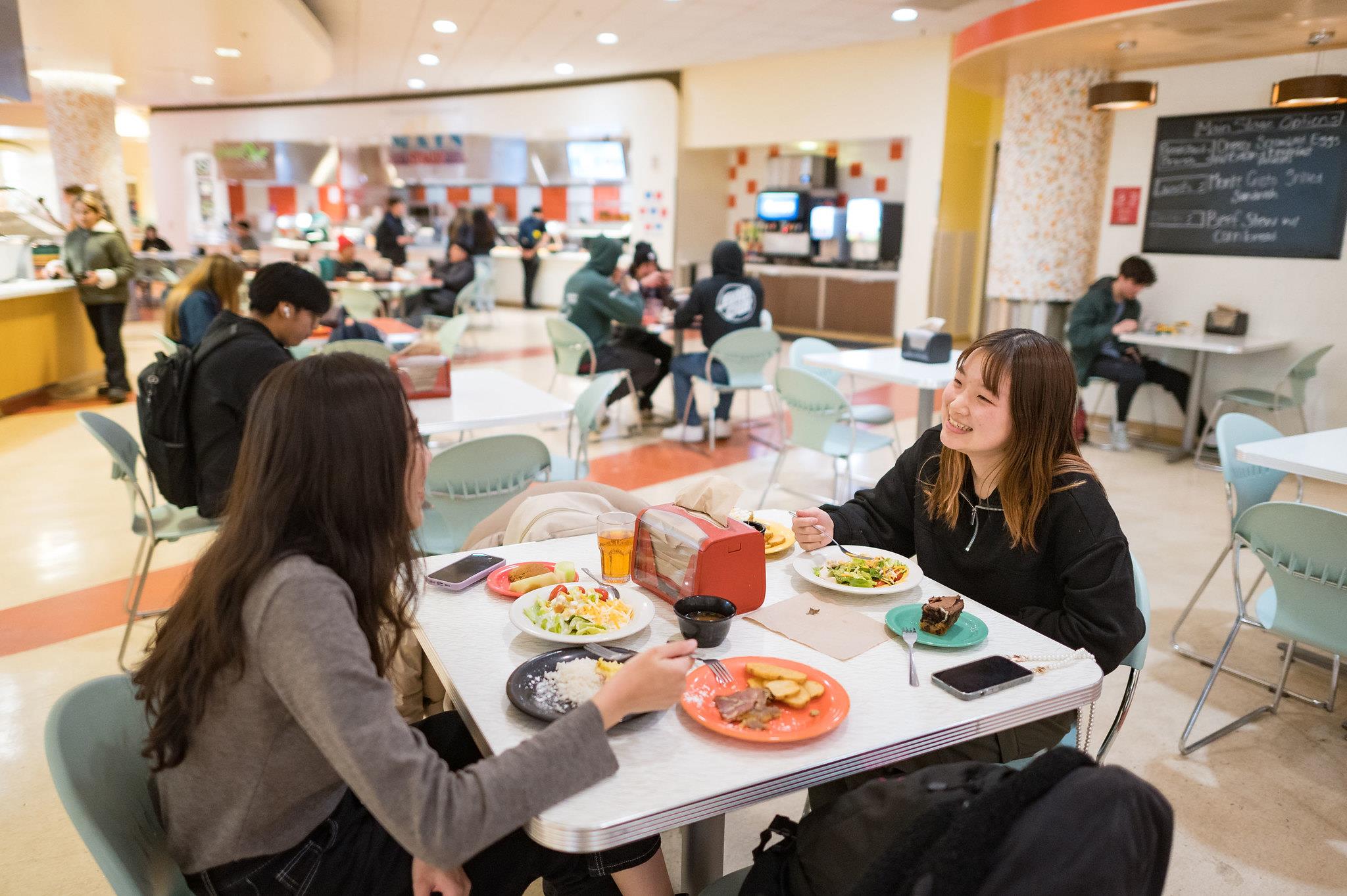 a group of students eating a meal in Estom Jamani dining hall